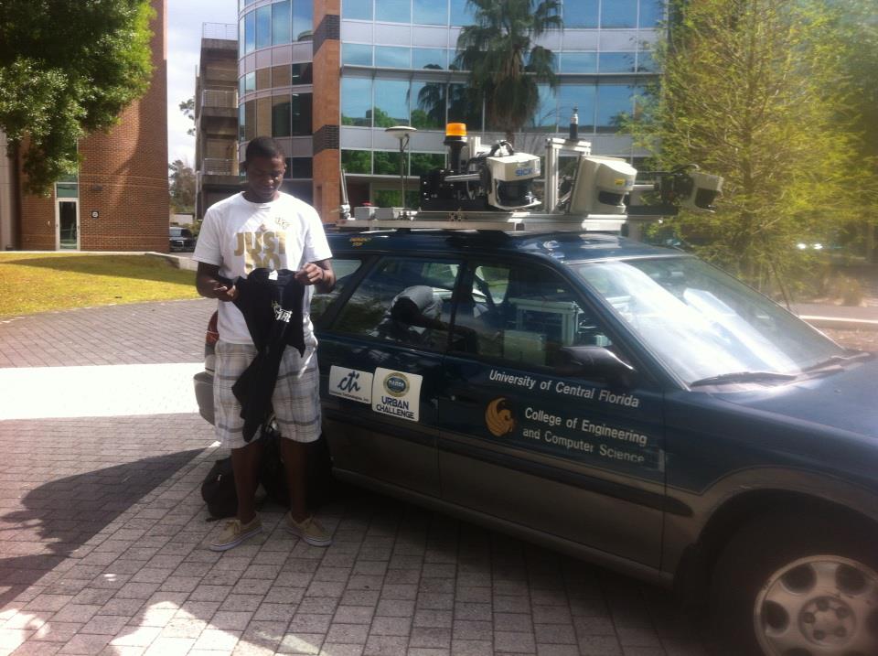Raikesson standing near self driving car while holding a shirt