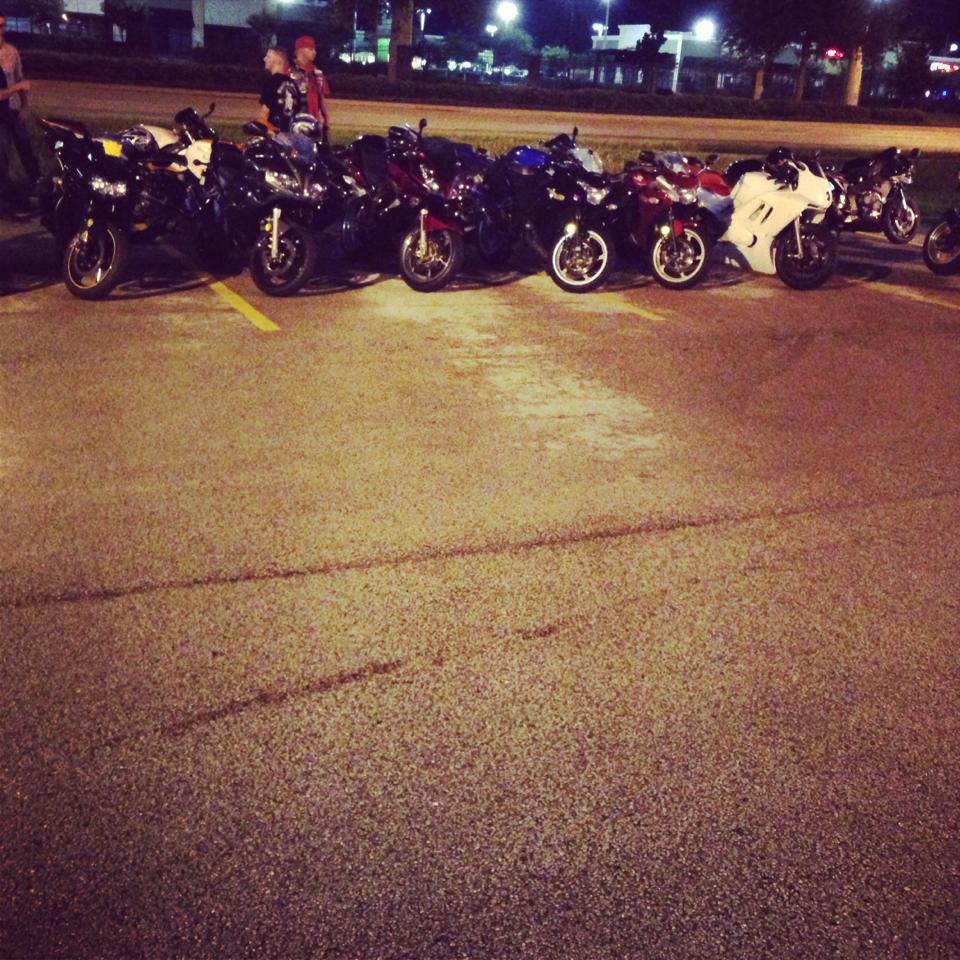 Multiple motrocycles aligned from left to right at a bikers night event